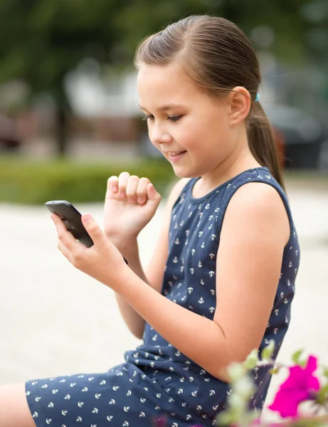 Menina está usando smartphone — Fotografia de Stock