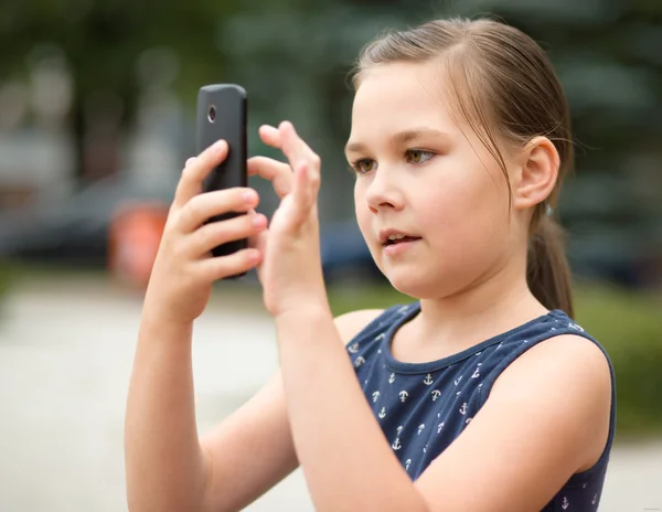 Chica está usando teléfono inteligente —  Fotos de Stock