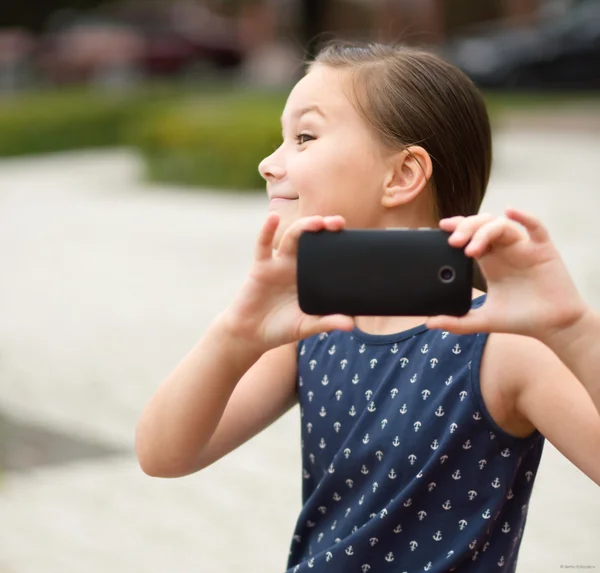 Menina está fotografando usando smartphone — Fotografia de Stock