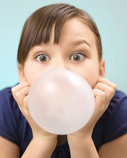 Menina está soprando chiclete grande — Fotografia de Stock