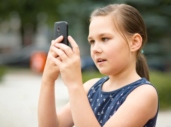 Chica está usando teléfono inteligente —  Fotos de Stock