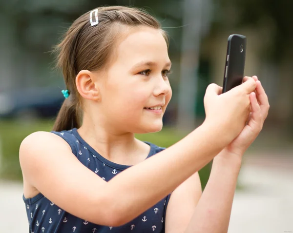 女の子は、スマート フォンを使用しています。 — ストック写真