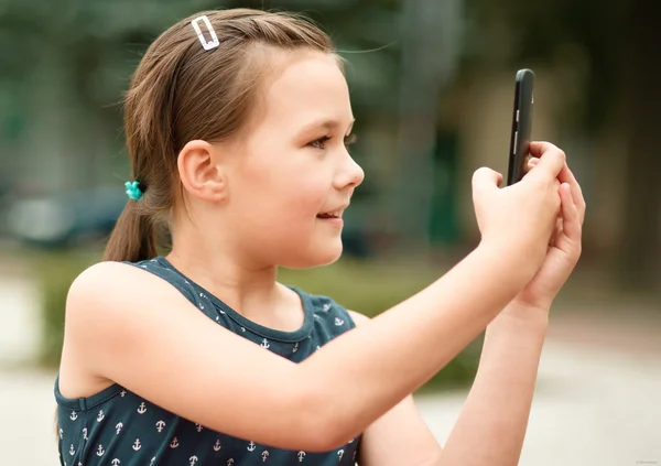 女の子は、スマート フォンを使用しています。 — ストック写真