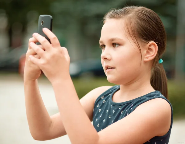 Menina está usando smartphone Imagens De Bancos De Imagens