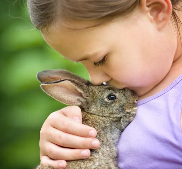 Girl is holding a little rabbit — Stock Photo, Image