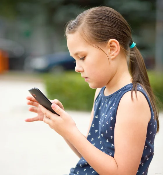 Menina está usando smartphone — Fotografia de Stock