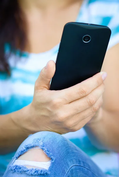 Mujer está utilizando el teléfono inteligente Imágenes de stock libres de derechos