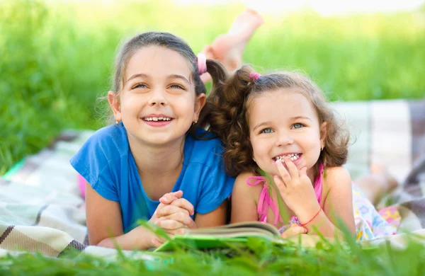 Twee kleine meisjes boek aan het lezen bent — Stockfoto