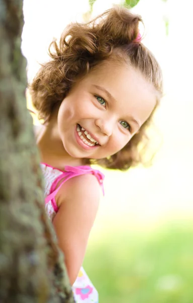 Милая маленькая девочка играет в прятки — стоковое фото