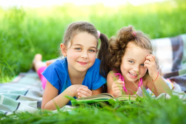 Zwei kleine Mädchen lesen Buch — Stockfoto