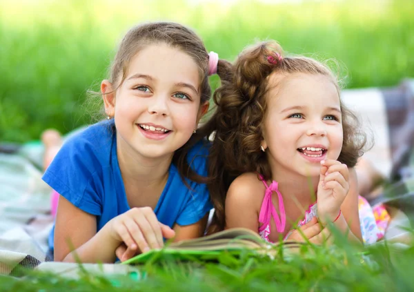 Twee kleine meisjes boek aan het lezen bent — Stockfoto