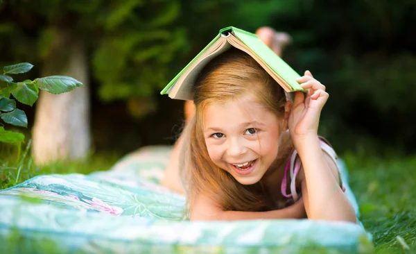 La bambina si nasconde sotto il libro all'aperto — Foto Stock