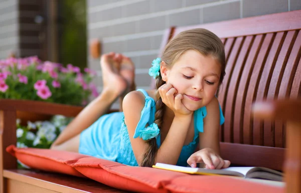 Liten flicka läser en bok — Stockfoto