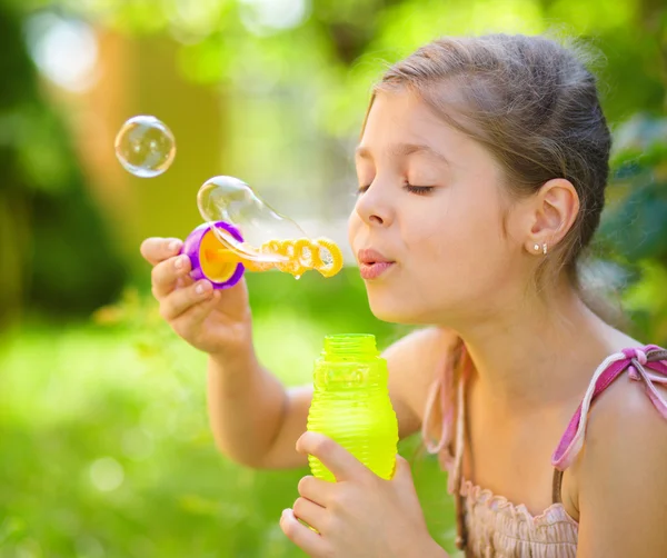 Ragazzina sta soffiando bolle di sapone — Foto Stock