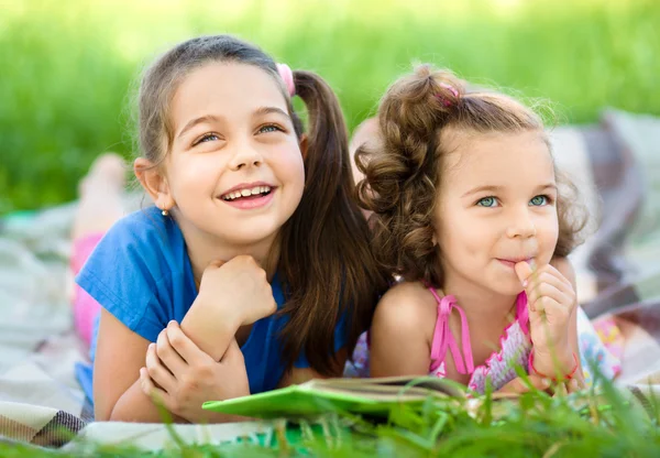 Twee kleine meisjes boek aan het lezen bent — Stockfoto