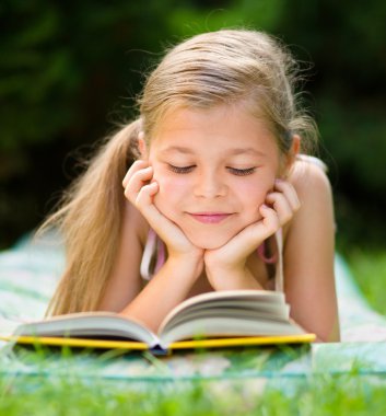 küçük kız açık havada bir kitap okuma