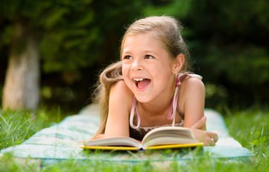 küçük kız açık havada bir kitap okuma