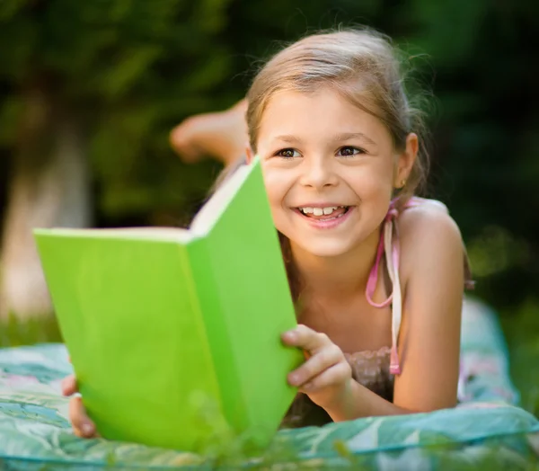 Menina está lendo um livro ao ar livre — Fotografia de Stock