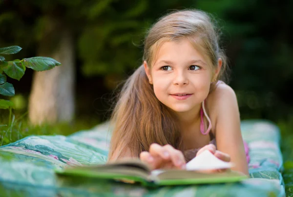 Petite fille lit un livre en plein air — Photo