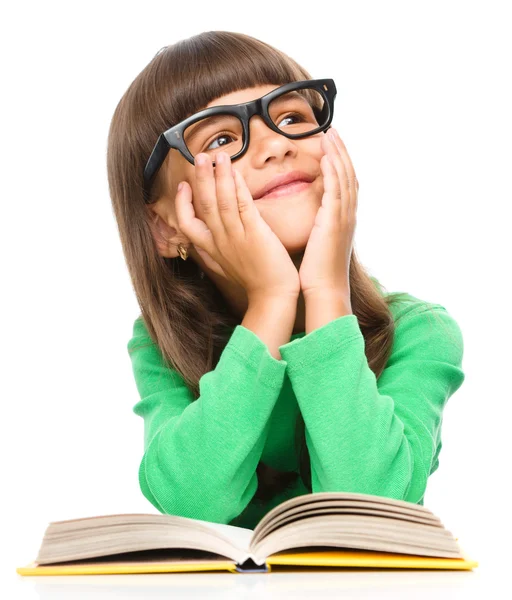 Young girl is daydreaming while reading book — Stock Photo, Image