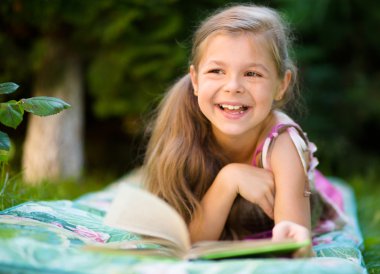 küçük kız açık havada bir kitap okuma
