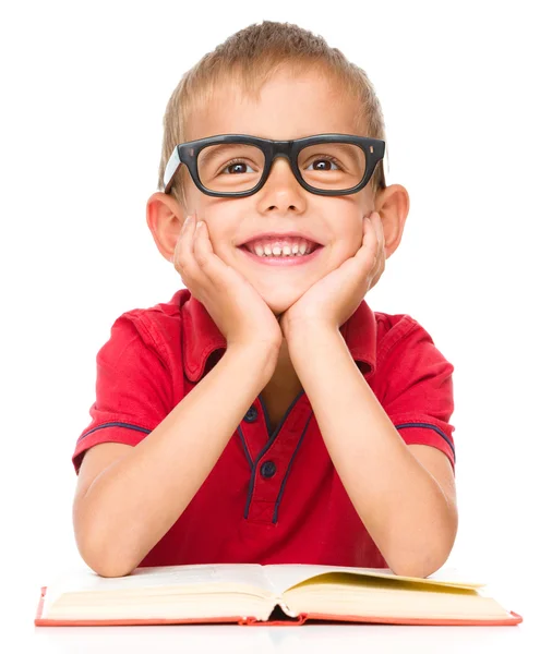 Liten pojke läser en bok — Stockfoto