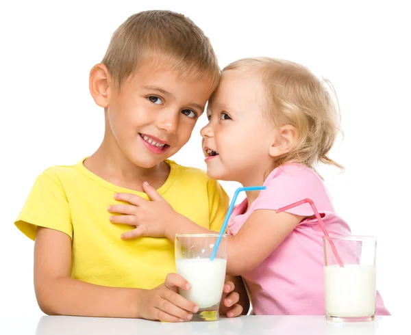 Mignonne petite fille et garçon boivent du lait — Photo