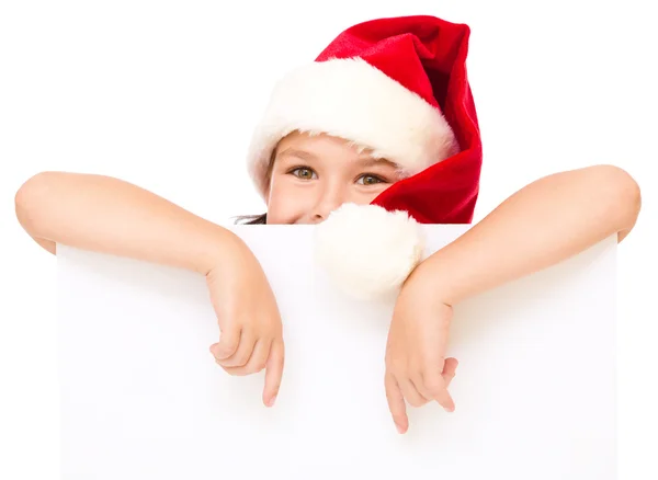 Niña en sombrero de santa está sosteniendo tablero en blanco —  Fotos de Stock