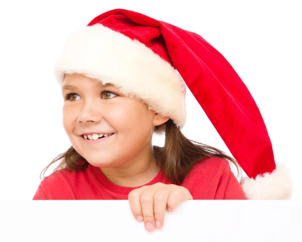 Little girl in santa hat is holding blank board Royalty Free Stock Photos
