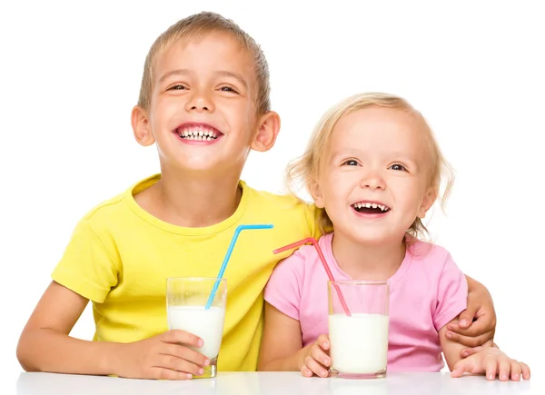 Симпатичные девочка и мальчик пьют молоко — стоковое фото