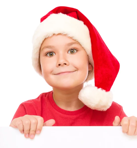 Niña en sombrero de santa está sosteniendo tablero en blanco — Foto de Stock