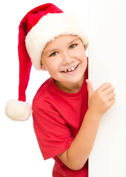 Little girl in santa hat is holding blank board — Stock Photo, Image