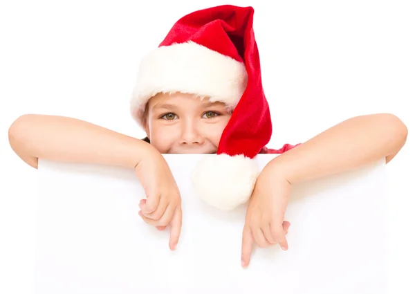 Niña en sombrero de santa está sosteniendo tablero en blanco —  Fotos de Stock