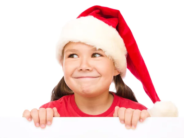 Niña en sombrero de santa está sosteniendo tablero en blanco —  Fotos de Stock