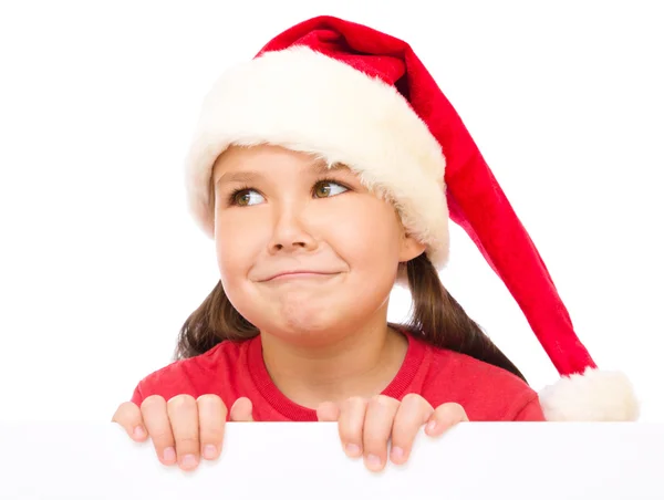 Niña en sombrero de santa está sosteniendo tablero en blanco —  Fotos de Stock