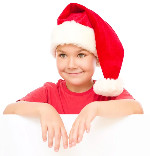 Noel Baba şapkası, küçük kız Pano düzenliyor — Stok fotoğraf