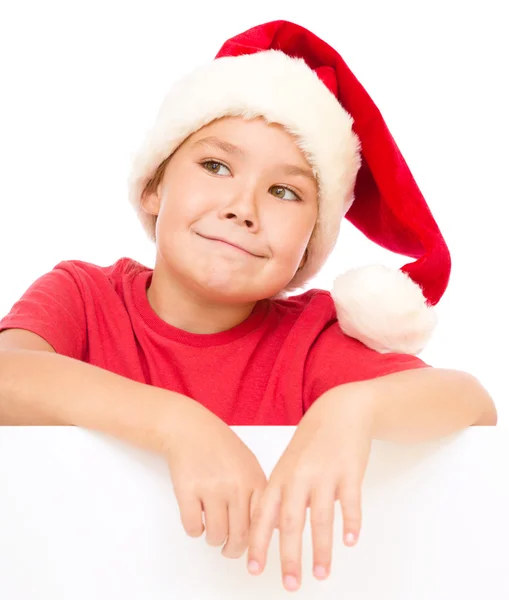 Little girl in santa hat is holding blank board — Stock Photo, Image