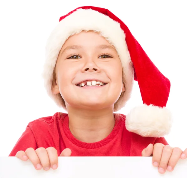 Little girl in santa hat is holding blank board — Stock Photo, Image