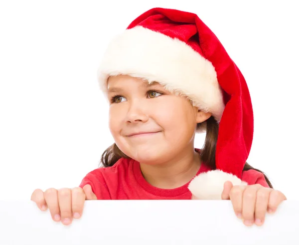 Niña en sombrero de santa está sosteniendo tablero en blanco — Foto de Stock