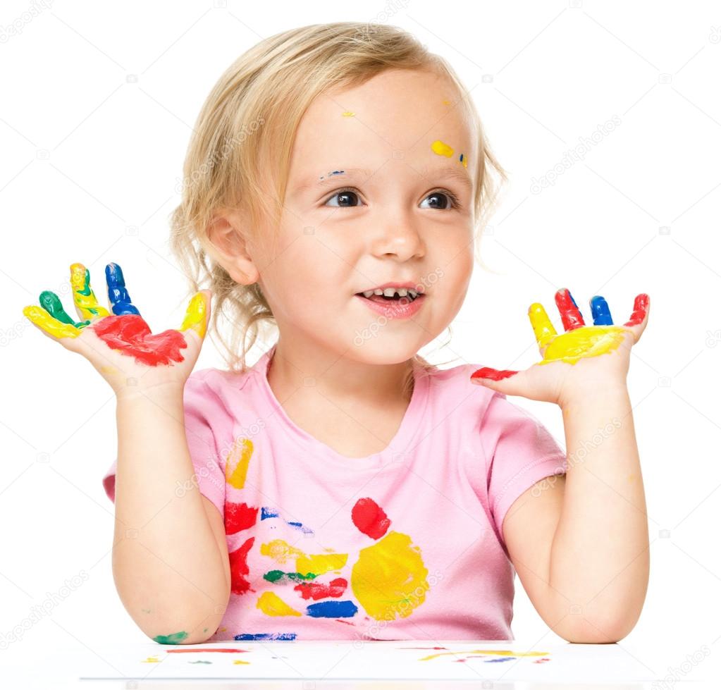 Portrait of a cute little girl playing with paints