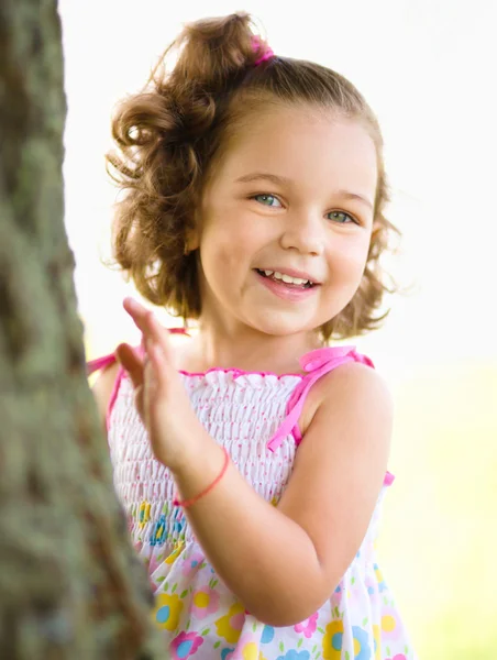 Милая маленькая девочка играет в прятки — стоковое фото