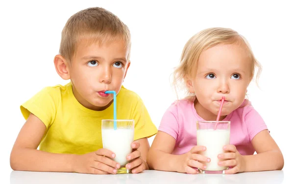 Mignonne petite fille et garçon boivent du lait — Photo