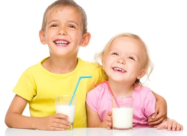 Mignonne petite fille et garçon boivent du lait — Photo