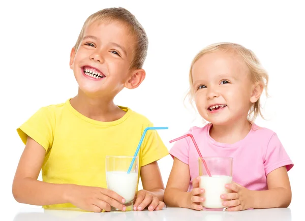 Mignonne petite fille et garçon boivent du lait — Photo