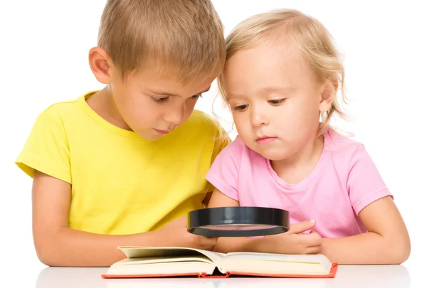 Niña y niño están leyendo el libro — Foto de Stock