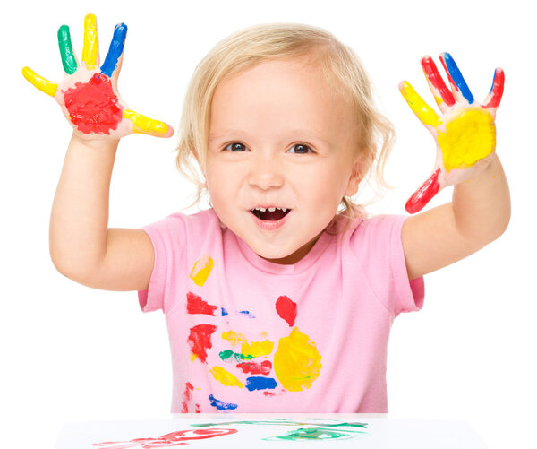 Portrait of a cute little girl playing with paints