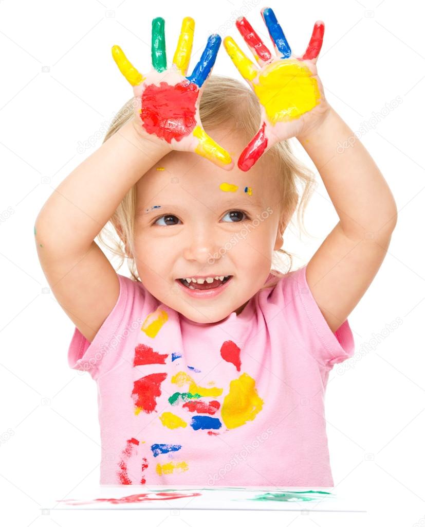 Portrait of a cute little girl playing with paints