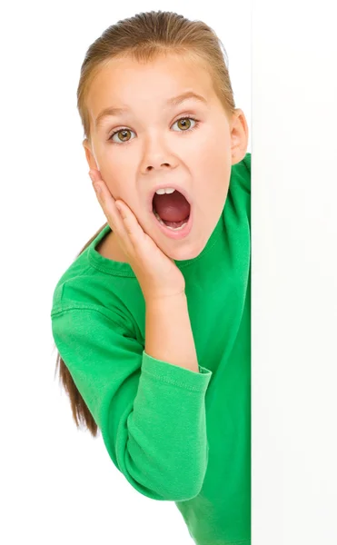 La ragazzina sta guardando fuori dal banner bianco — Foto Stock