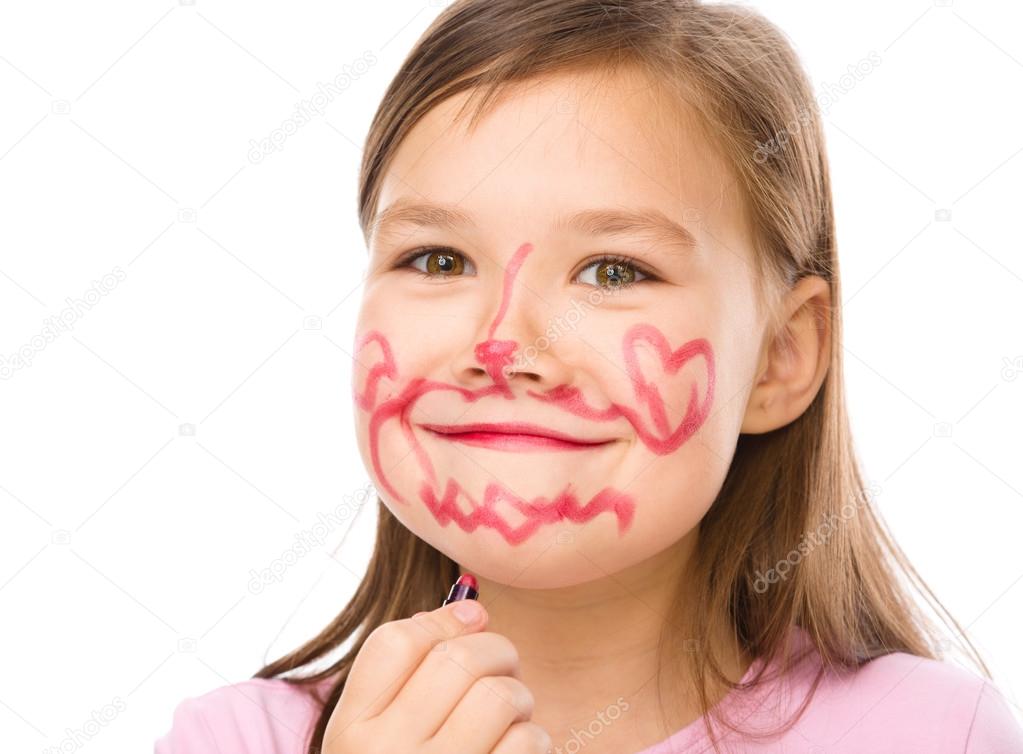 Little girl is applying lipstick on her cheek — Stock Photo © Kobyakov