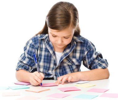 Girl is writing on color stickers using pen clipart